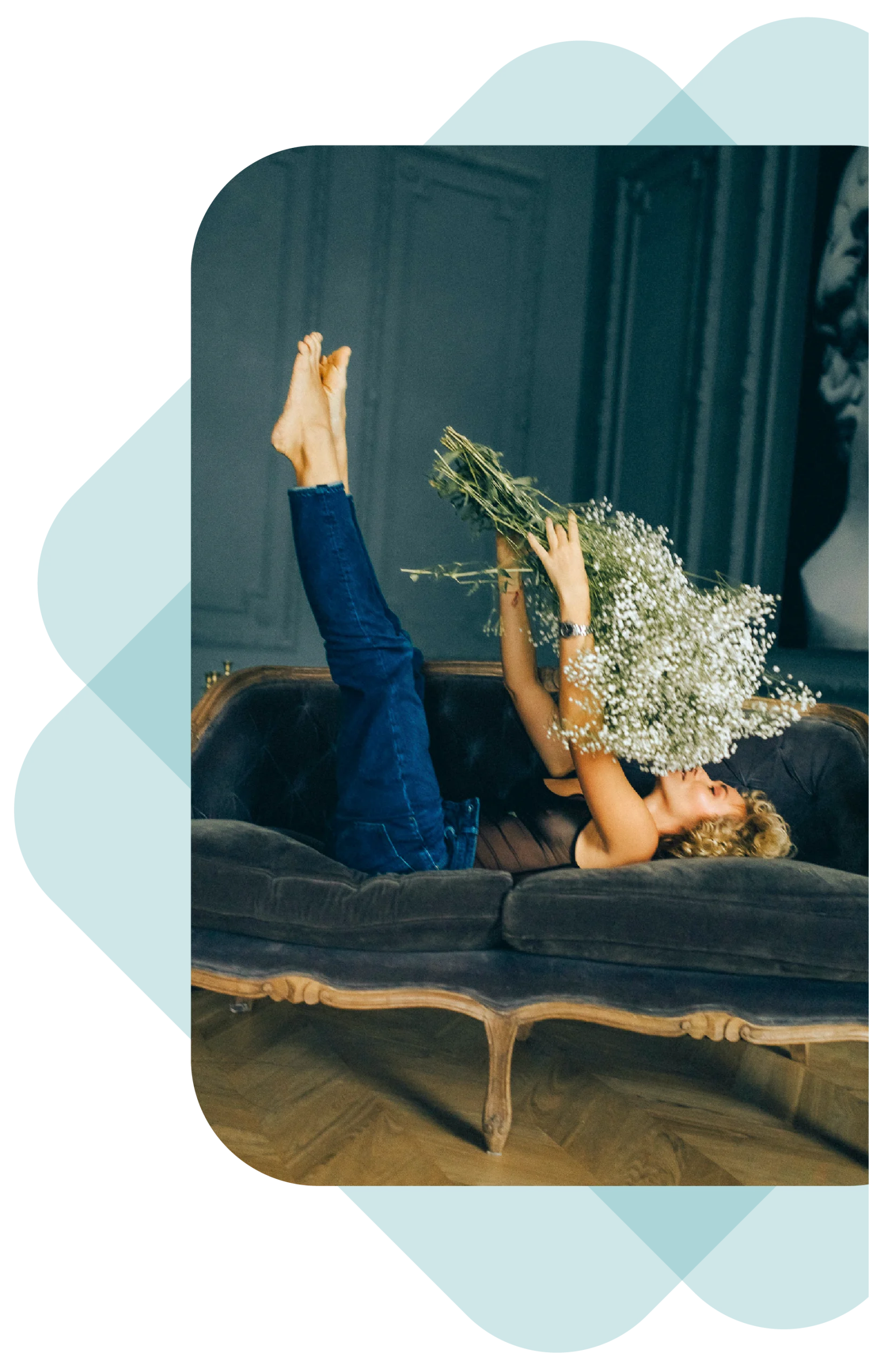 Femme allongé sur un canapé entrain de sentir un bouquet de fleur